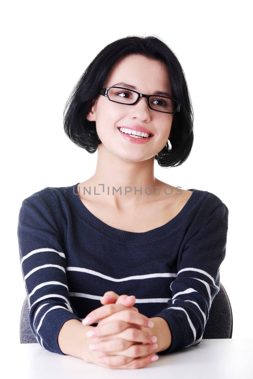 Smiling student girl sitting at the desk, isolated on white