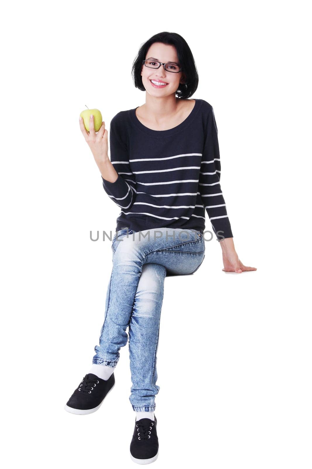 Young woman holding green fresh apple in hand, isolated over white background