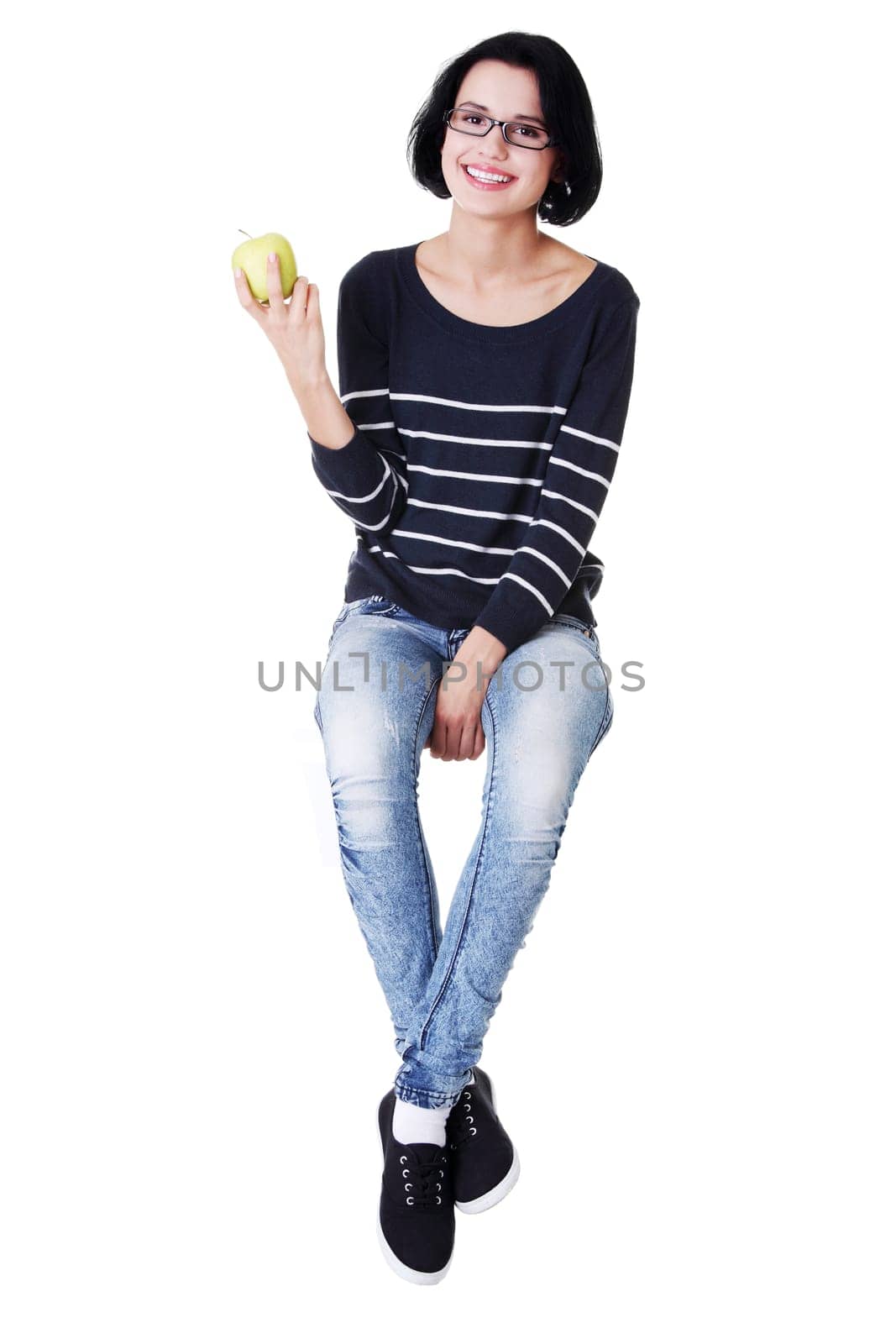 Young woman holding green fresh apple in hand, isolated over white background