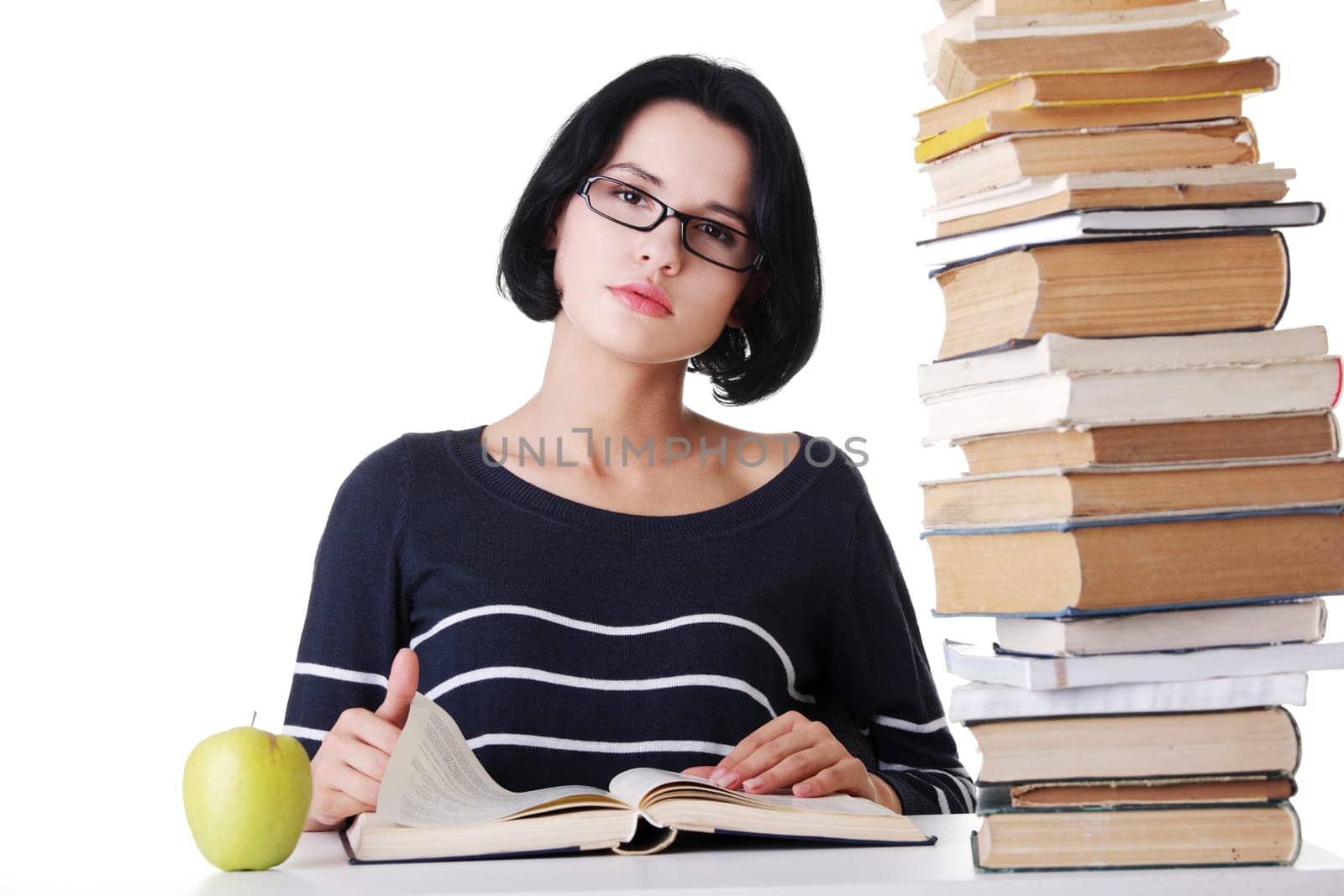 Young student woman with books studying at the desk, isolated on white background