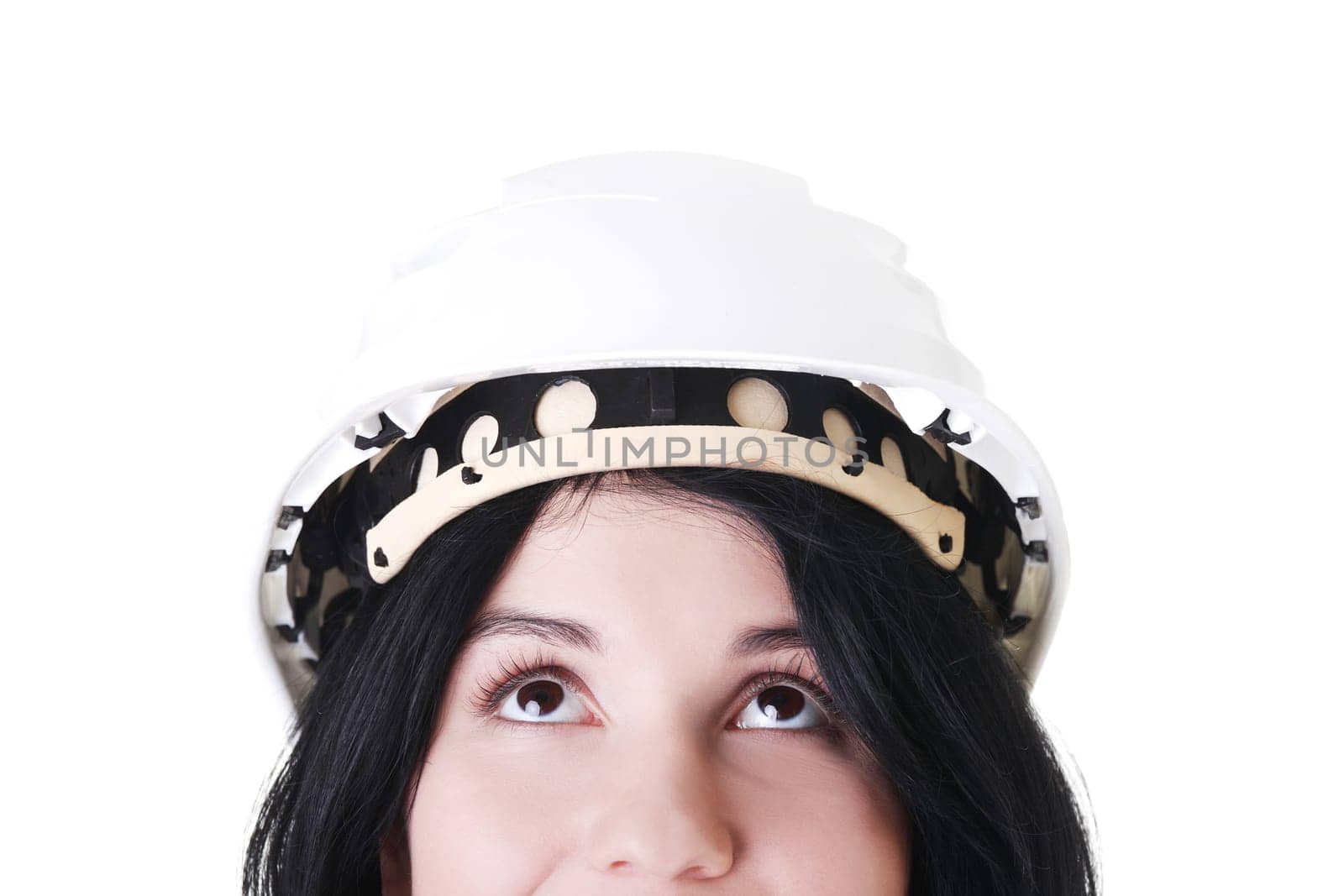 Portrait of confident female worker in helmet looking up. Isolated on white