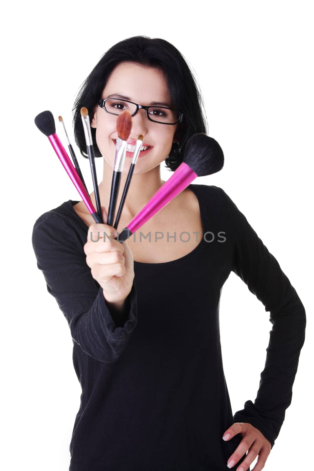 Young make-up artist woman holding brushes