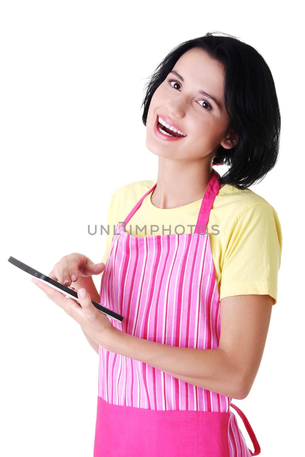 Young woman in pink apron using tablet computer, isolated