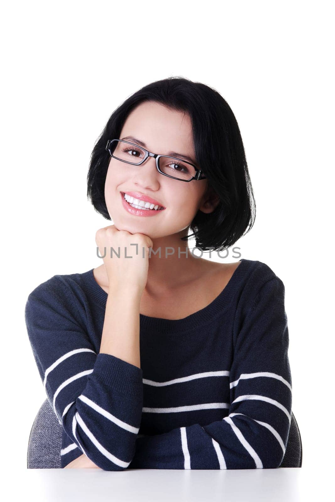Smiling student girl sitting at the desk, isolated on white