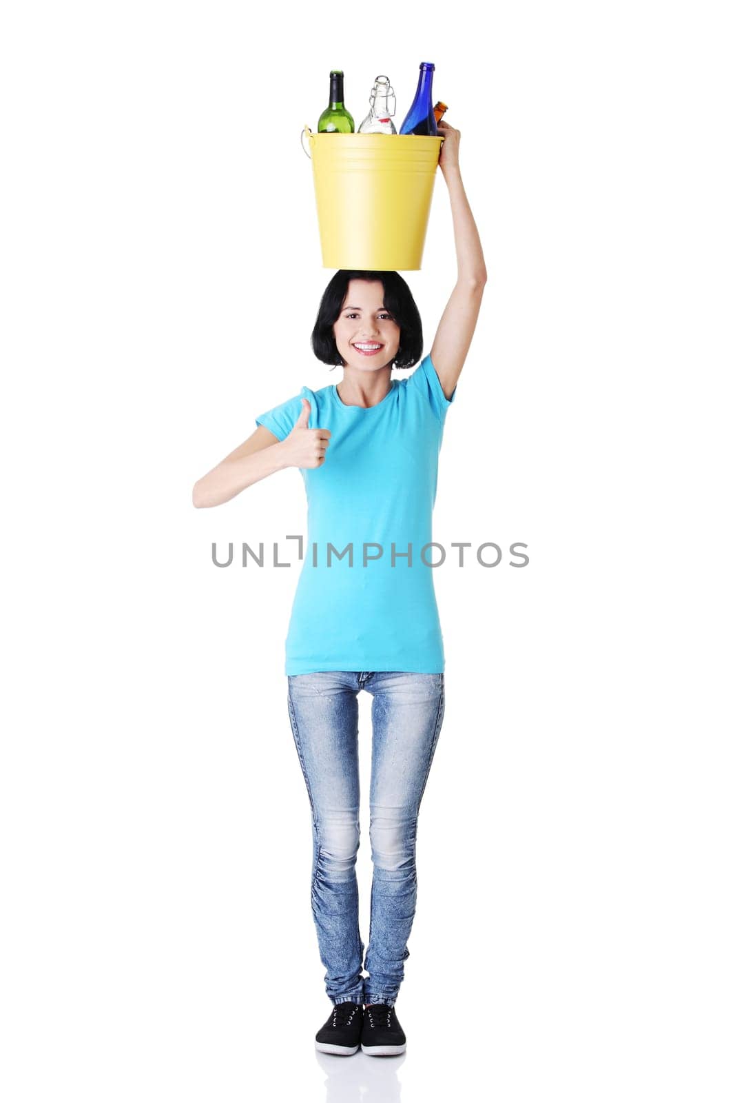 Young woman carrying a bin full of empty recyclable glass bottles. Recycling concept