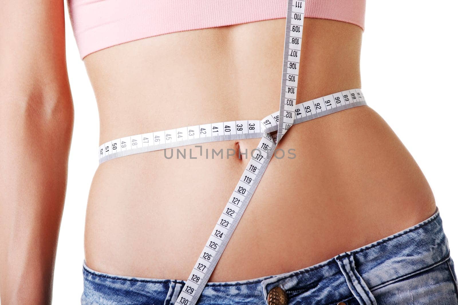 Young woman measuring her waist with tape
