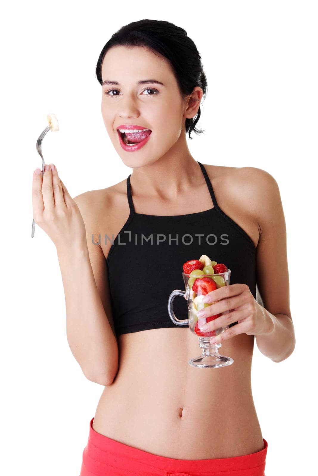 Pretty fit woman eating fruit salad , isolated on white