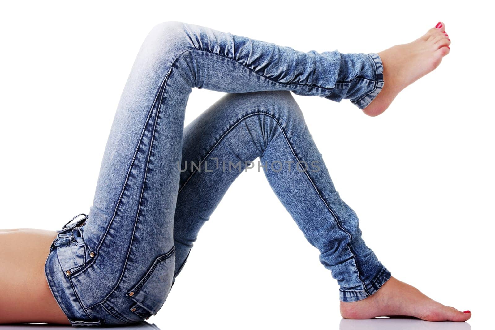 Fit female body in blue jeans, isolated on white