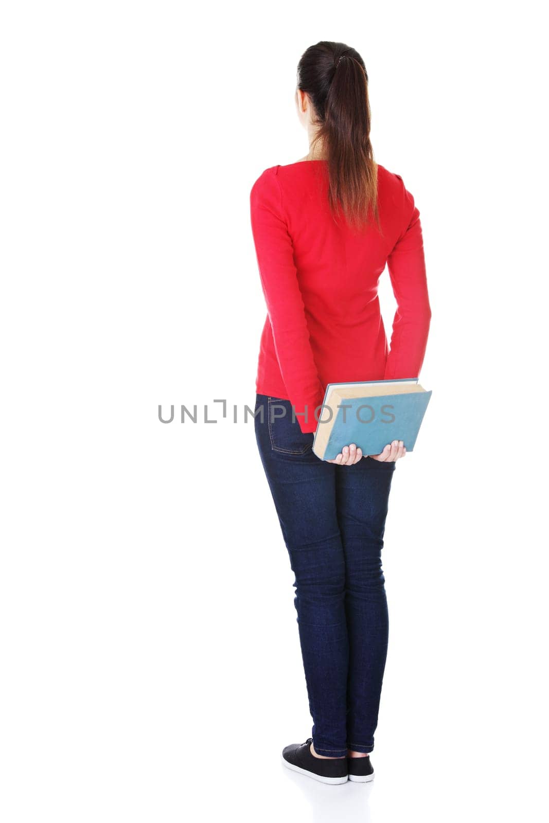 Back view of young student woman holding an old book. Isolated over white background.