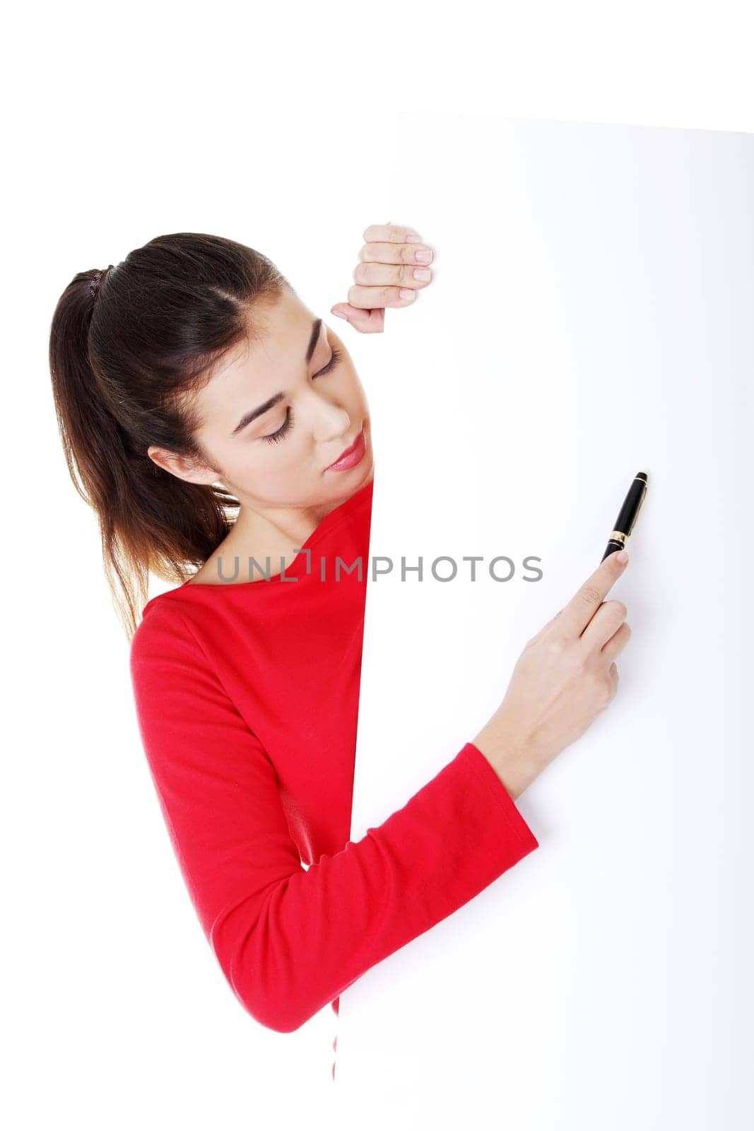Happy beautiful woman writing with a pen on blank board. Student or businesswoman.