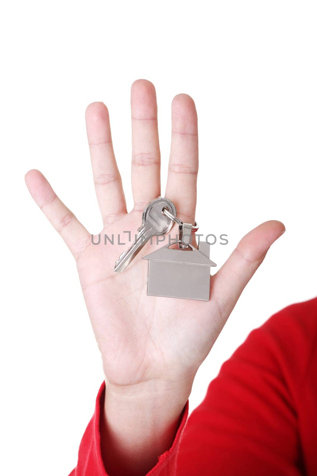 Hand holding a house key. Isolated on white background.