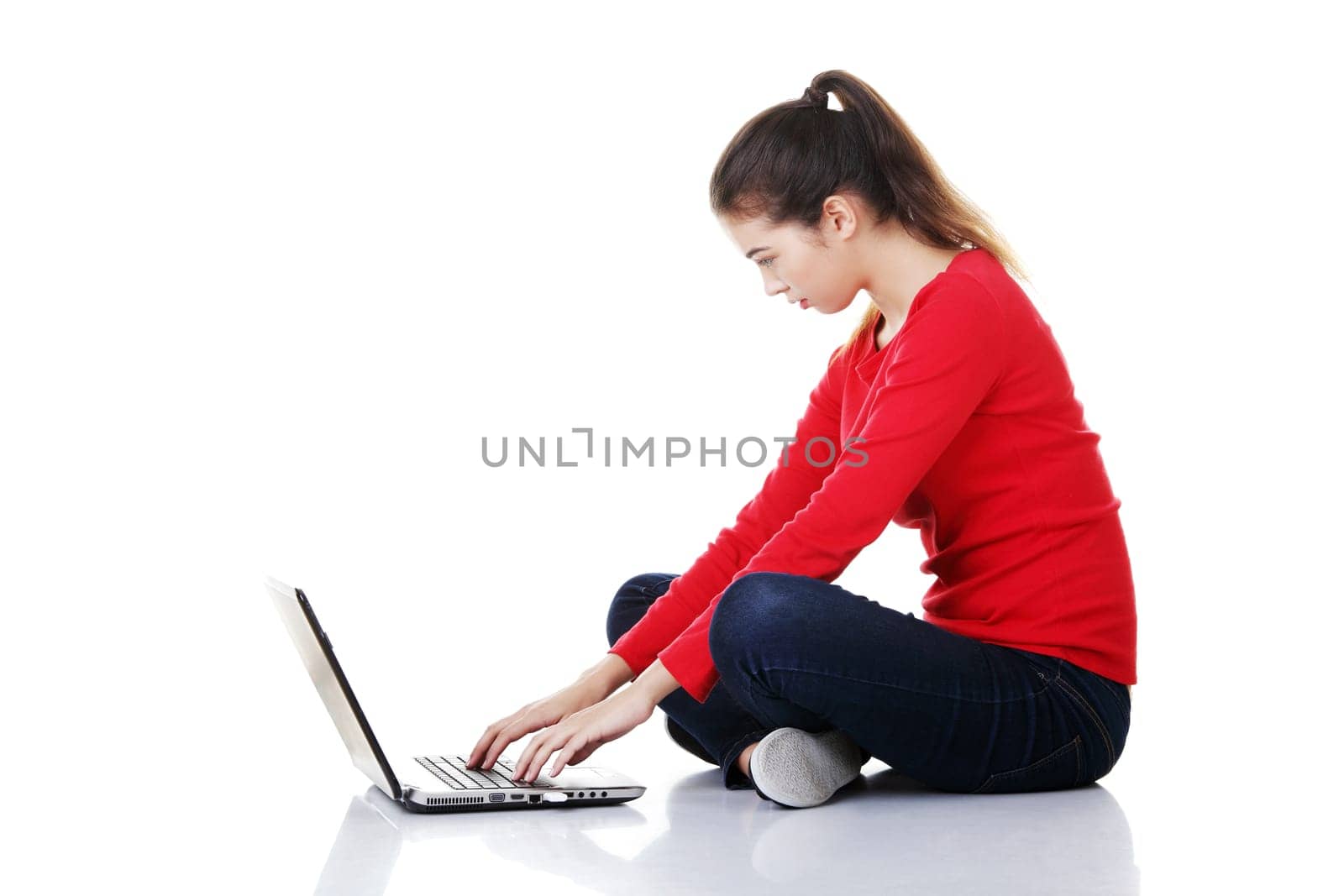 Happy young woman using her laptop, isolated on white.