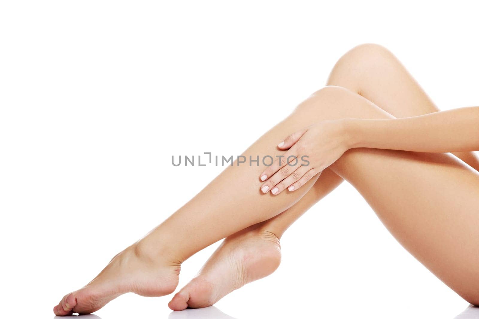 Beautiful female legs touched by hand , isolated on white