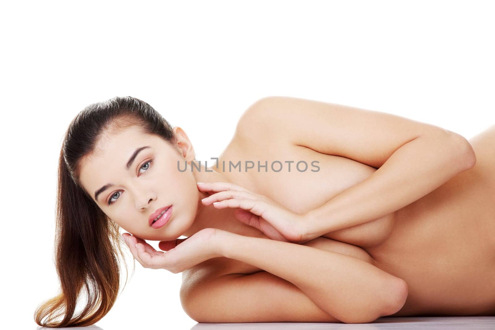 Sexy fit naked woman with healthy clean skin lying down, isolated on white