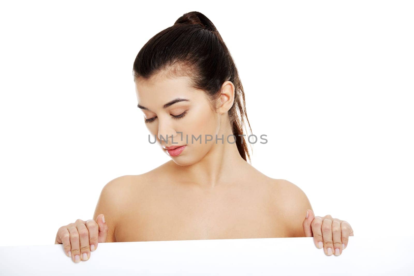 Sexy naked brunette holding empty board , isolated on white.