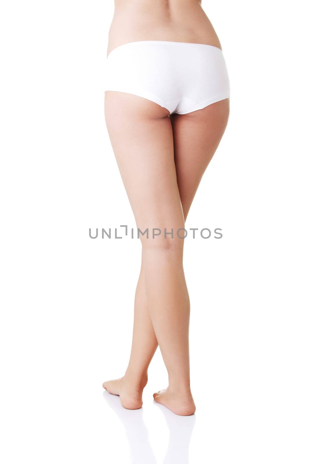 Slim tanned woman's body in black panties. Isolated over white background.