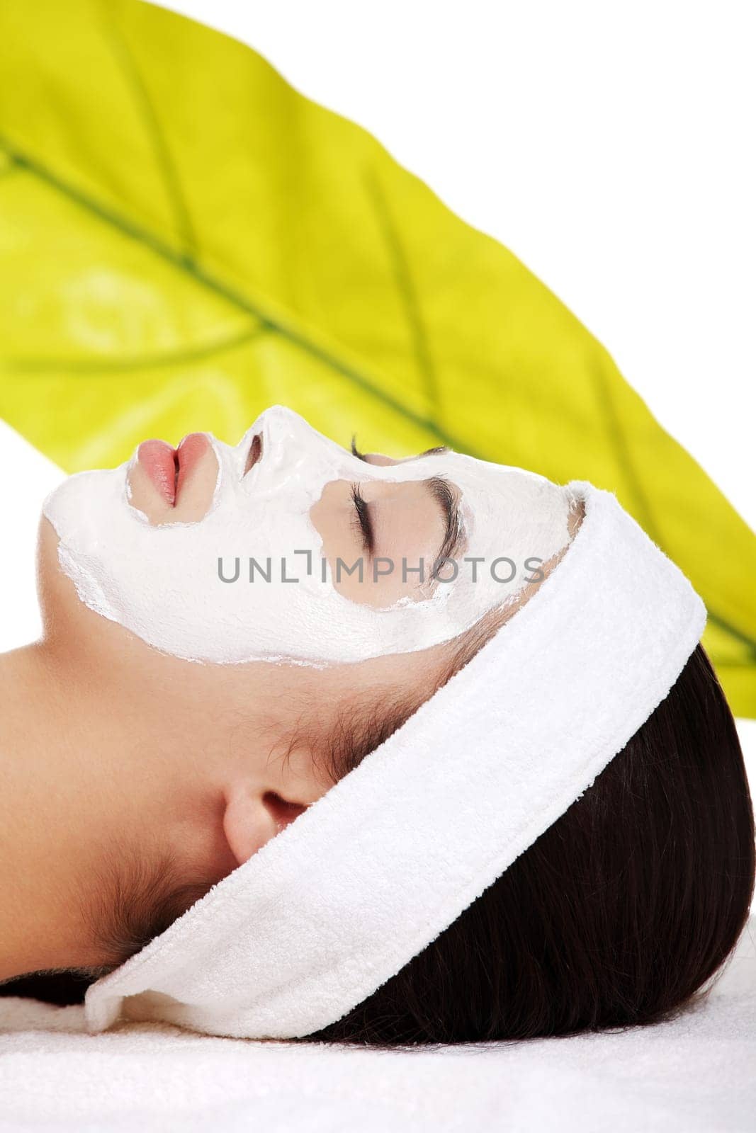 Beautiful woman with clay facial mask, isolated on white