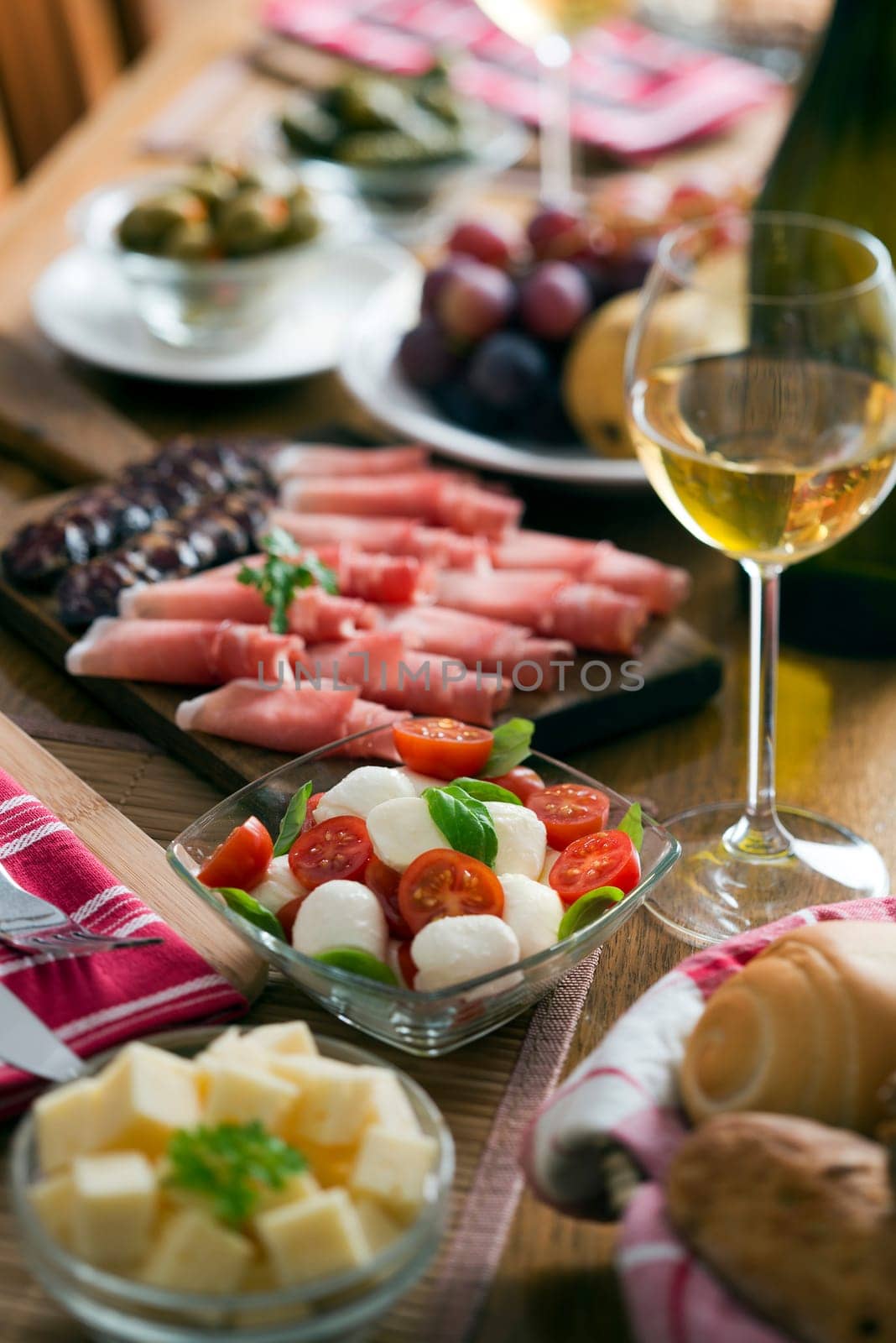 Fresh caprese salad on table full of food