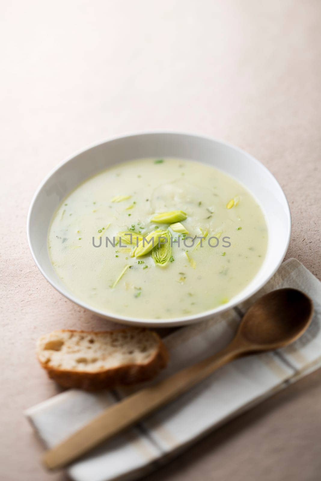 Fresh leek soup with bread close up shoot