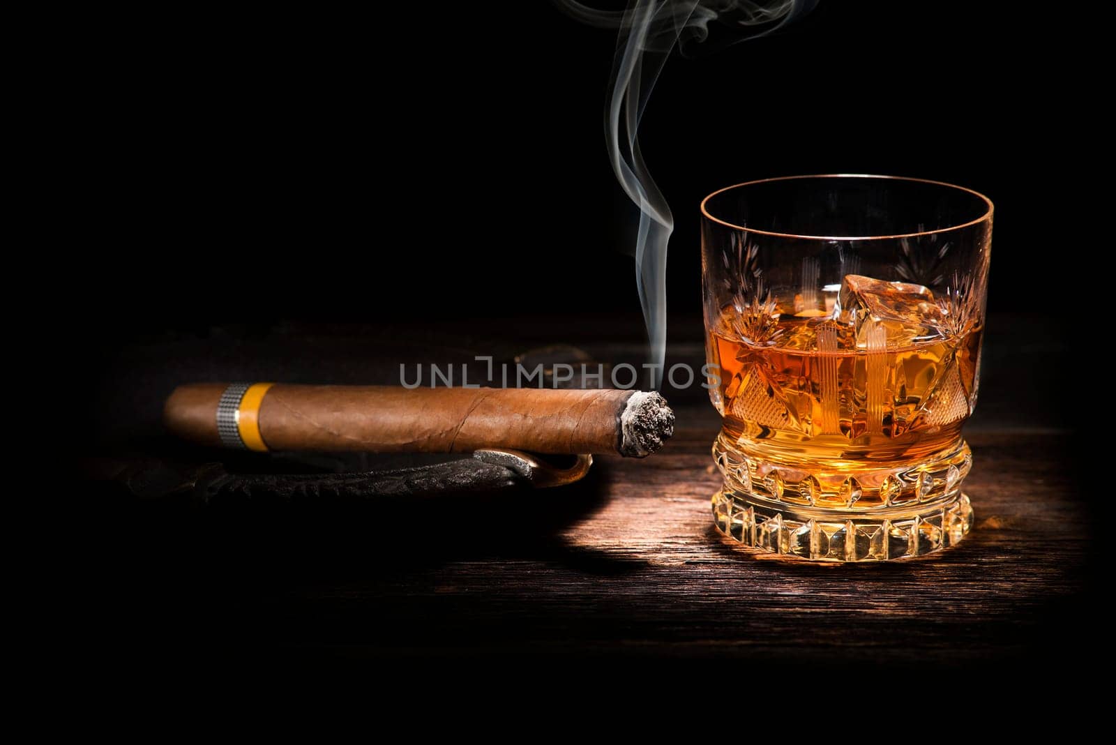 Whiskey and cigar on wooden background close up