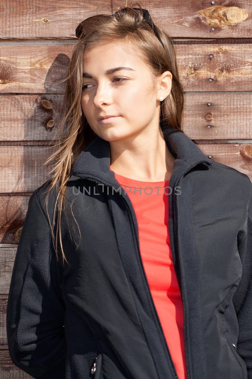 portrait of a beautiful girl on the background of the old wooden wall boards