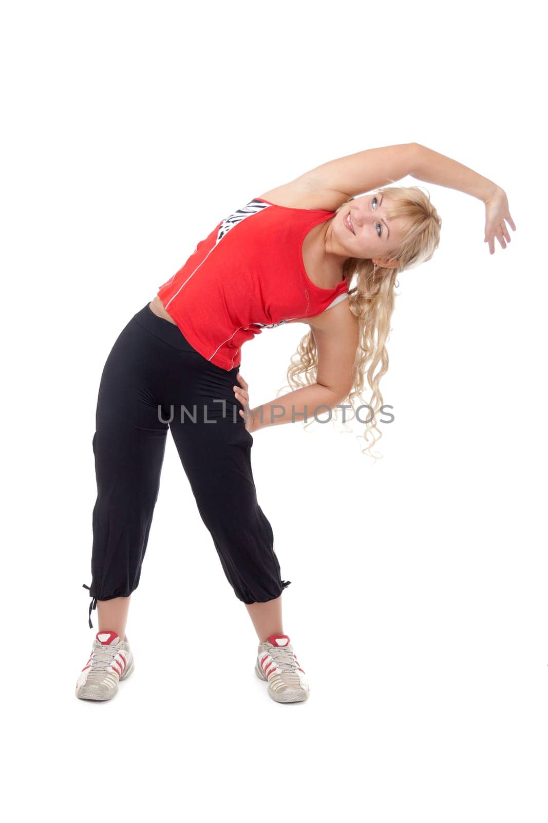 Beautiful girl in sportswear doing side bends. Isolate on white.
