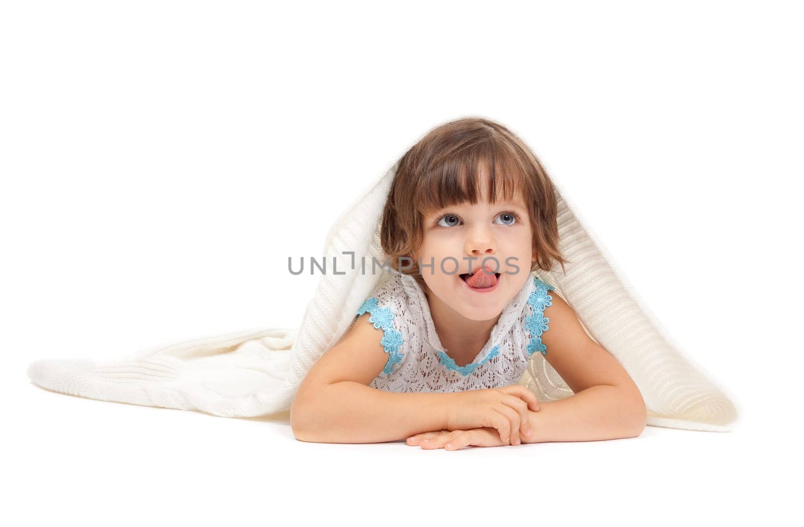 Little girl lying on the floor wrapped in a light blanket and tongue. Isolate on white.