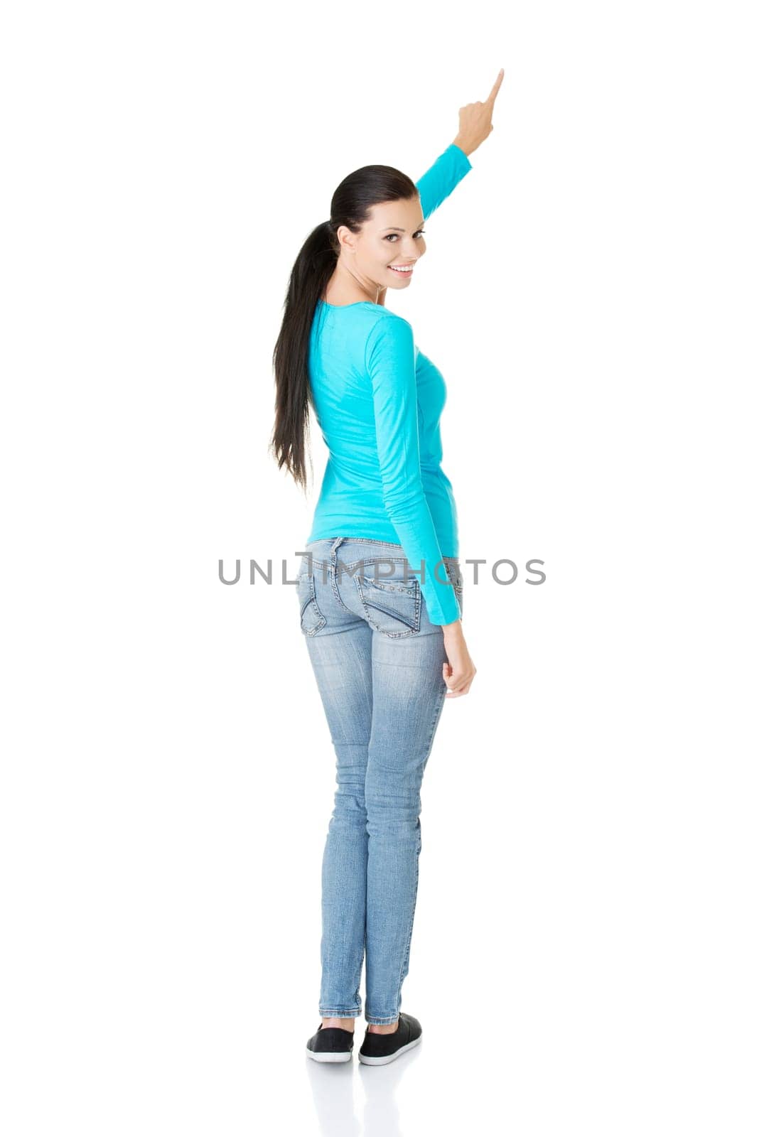 Happy , excited young woman pointing on copy space, isolated on white