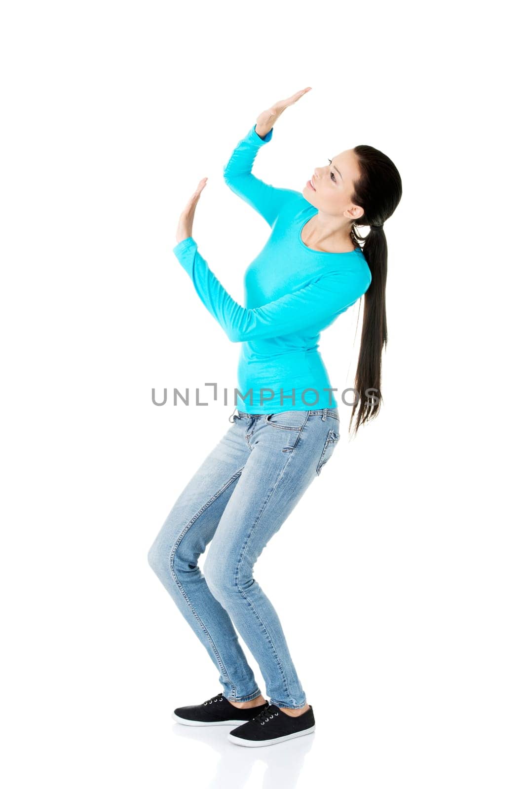 Scared young woman afraid of something above her, isolated on white
