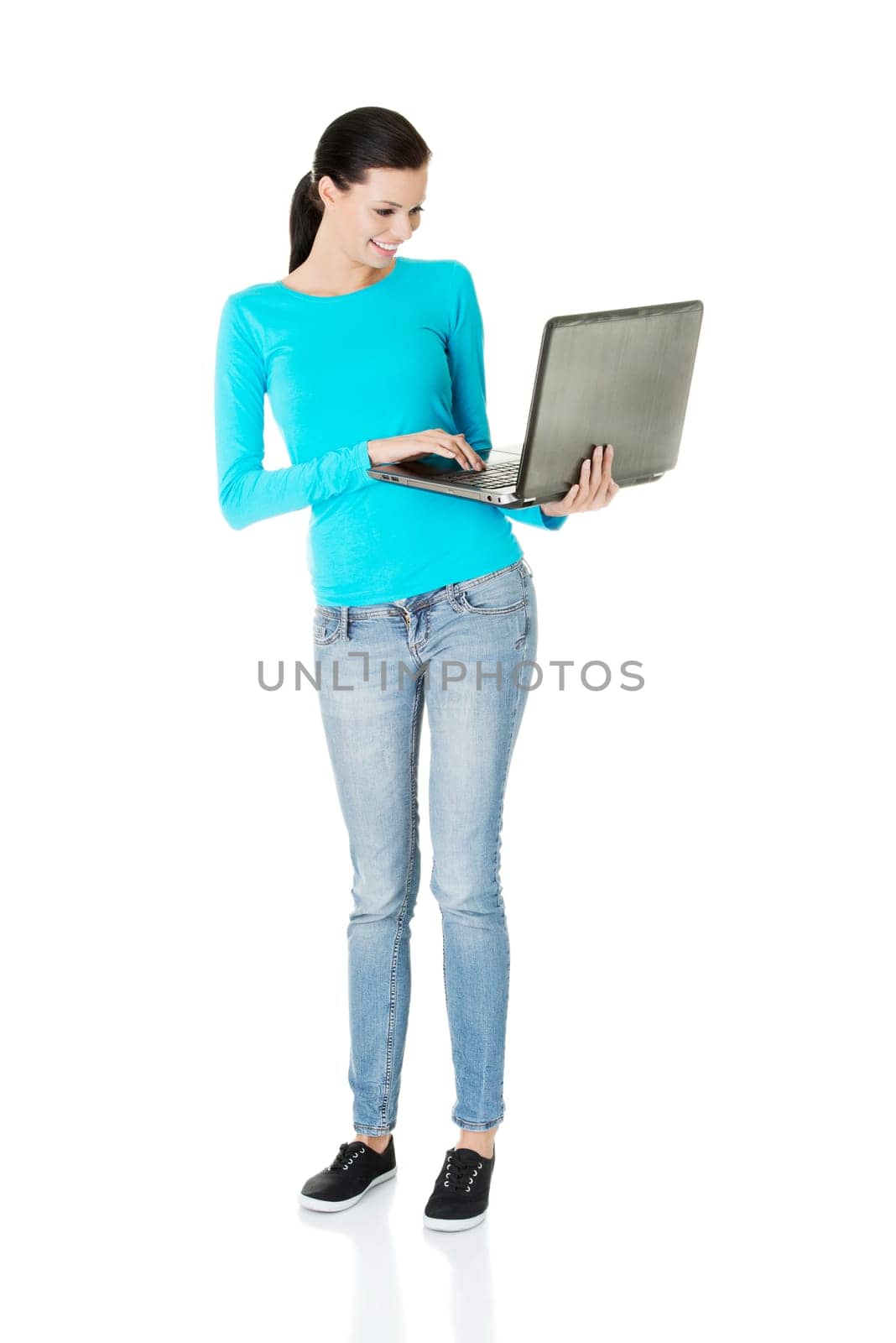 Happy young woman using her laptop, isolated on white.