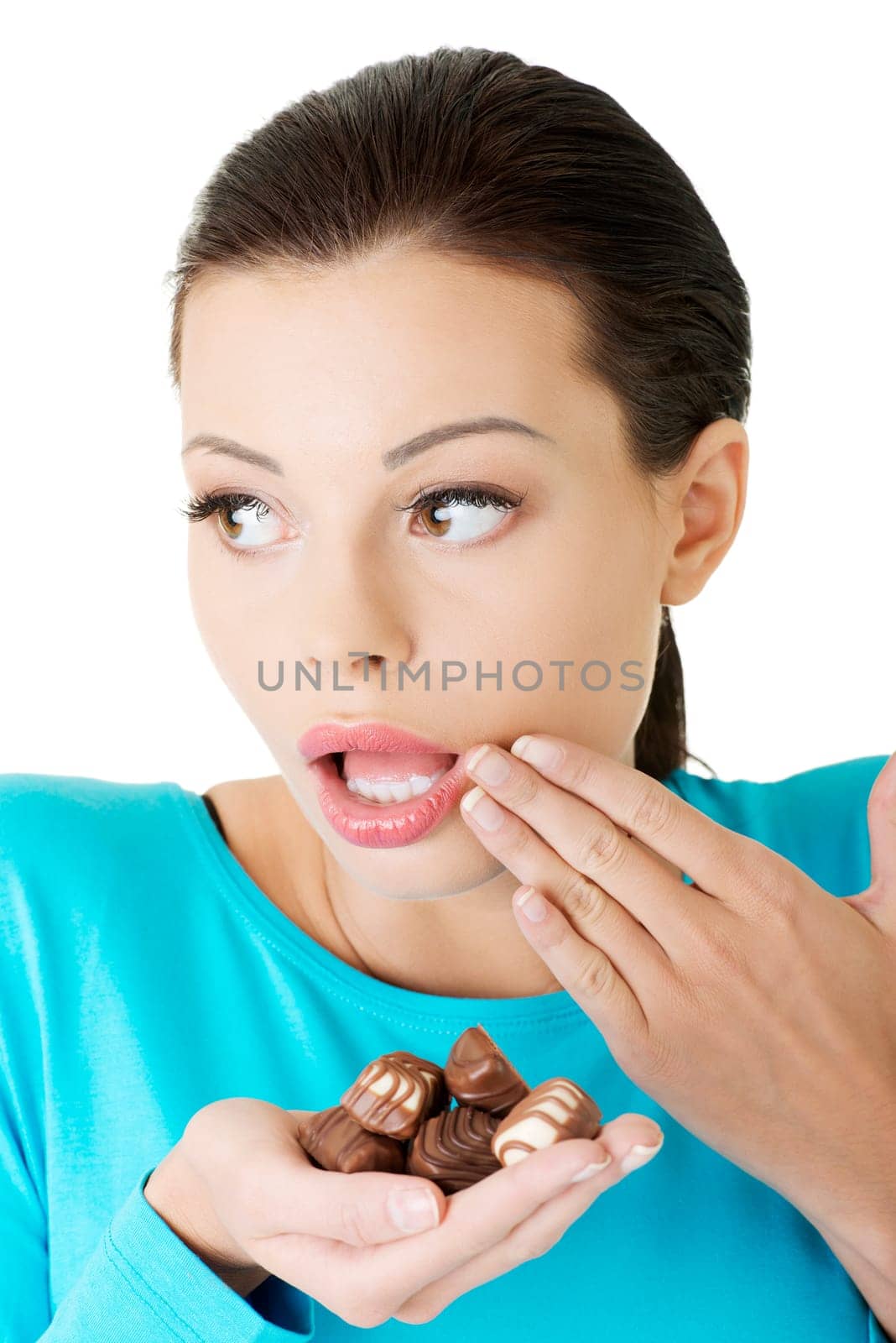 Embarrassment beautiful woman with hand full of chocolates