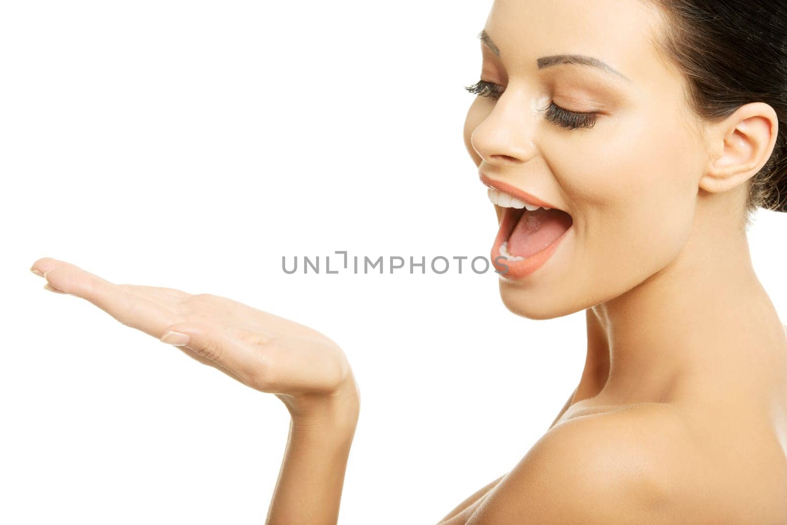 Attractive woman with clean fresh skin presenting copy space on her palm