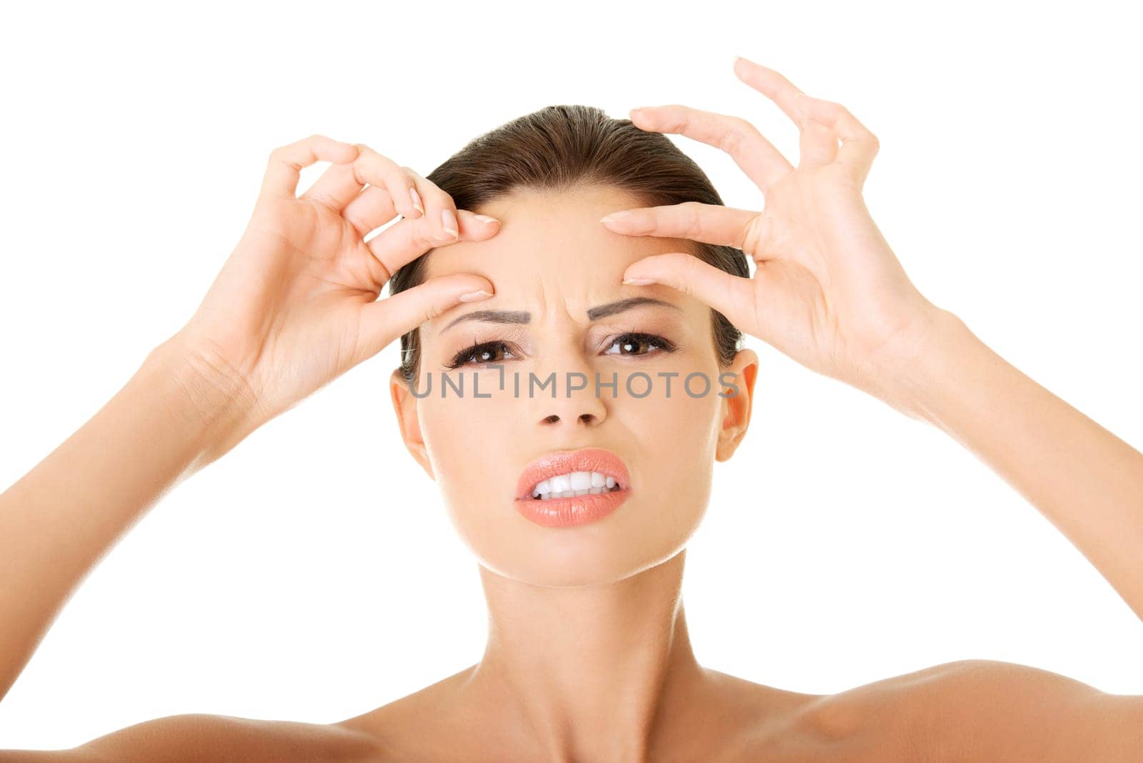 Woman checking her wrinkles on her forehead - isolated on white