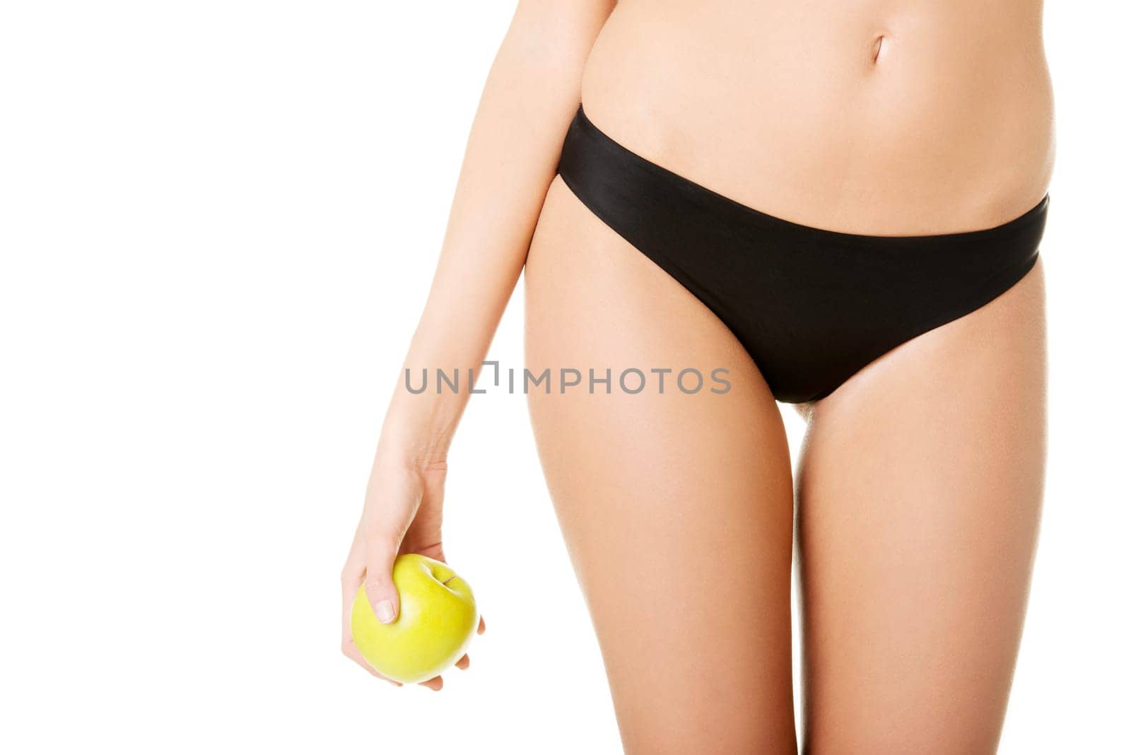 Beautiful fit sensual female body and apple isolated on white background