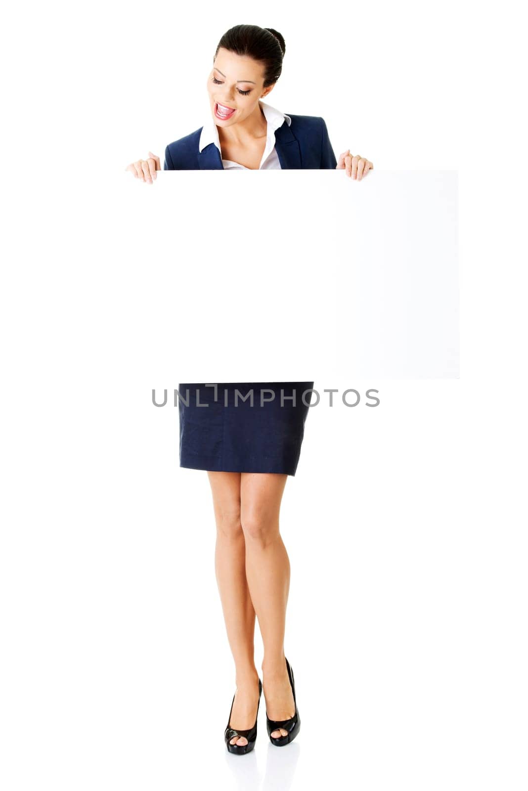 Smiling young business woman showing blank signboard, over white background isolated