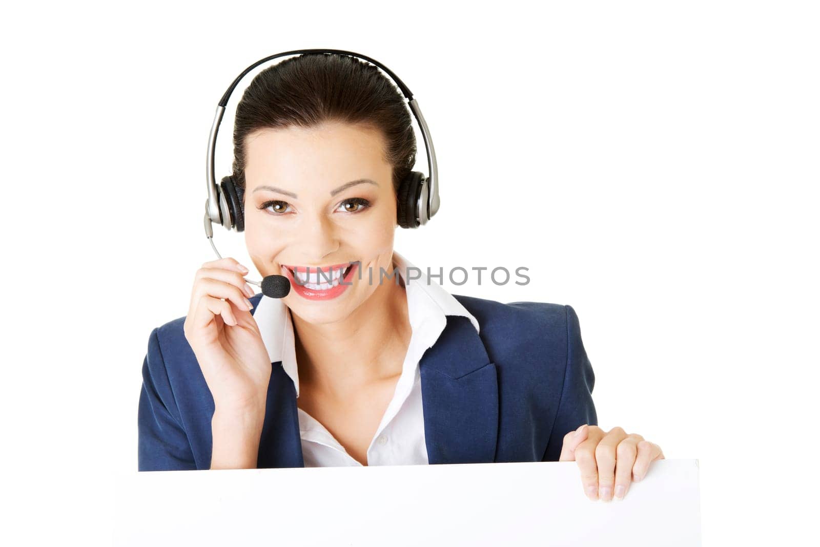Pretty young call center worker wearing a headset and holding blank sign board
