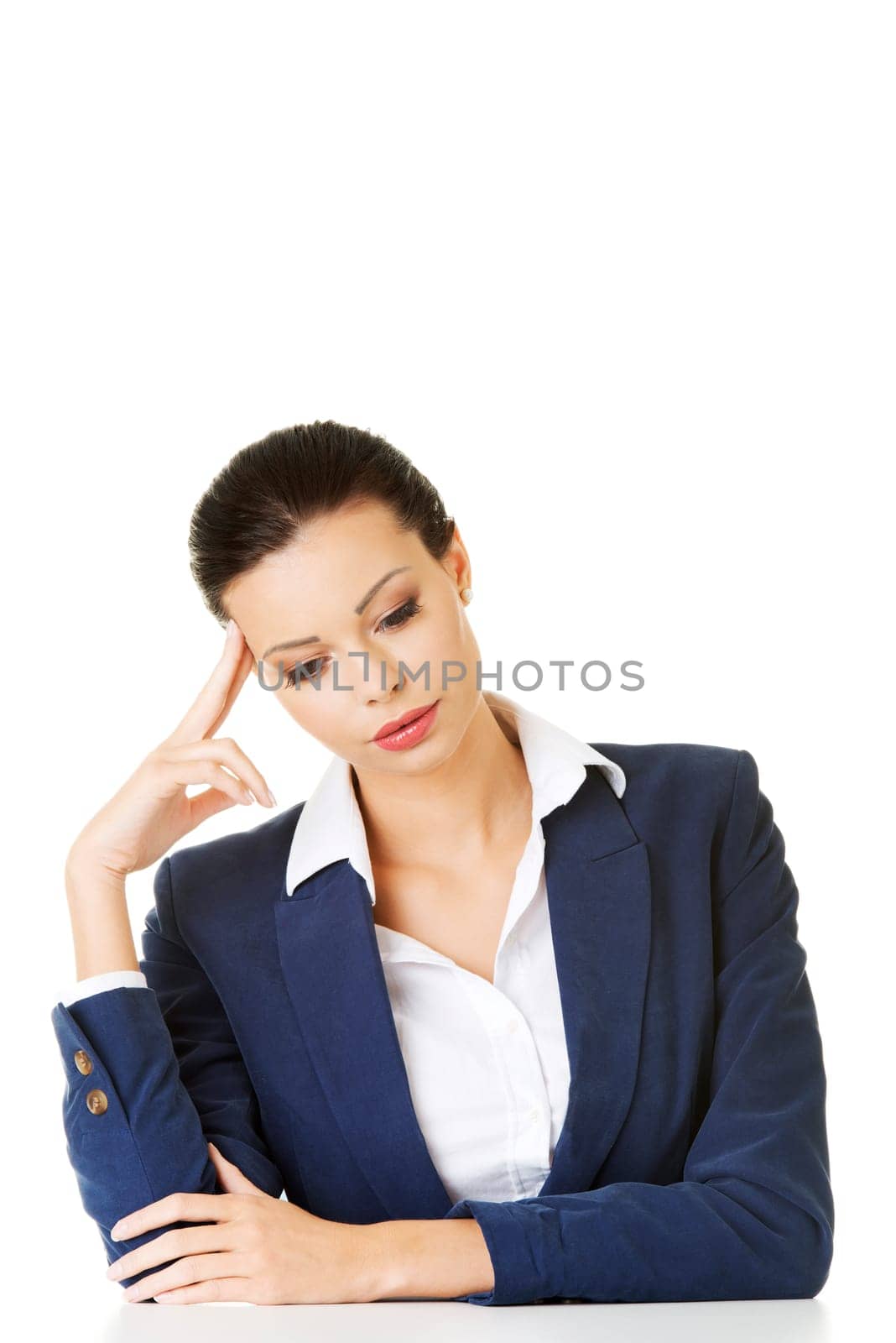 Sad businesswoman sitting behind the desk, isolated on white background