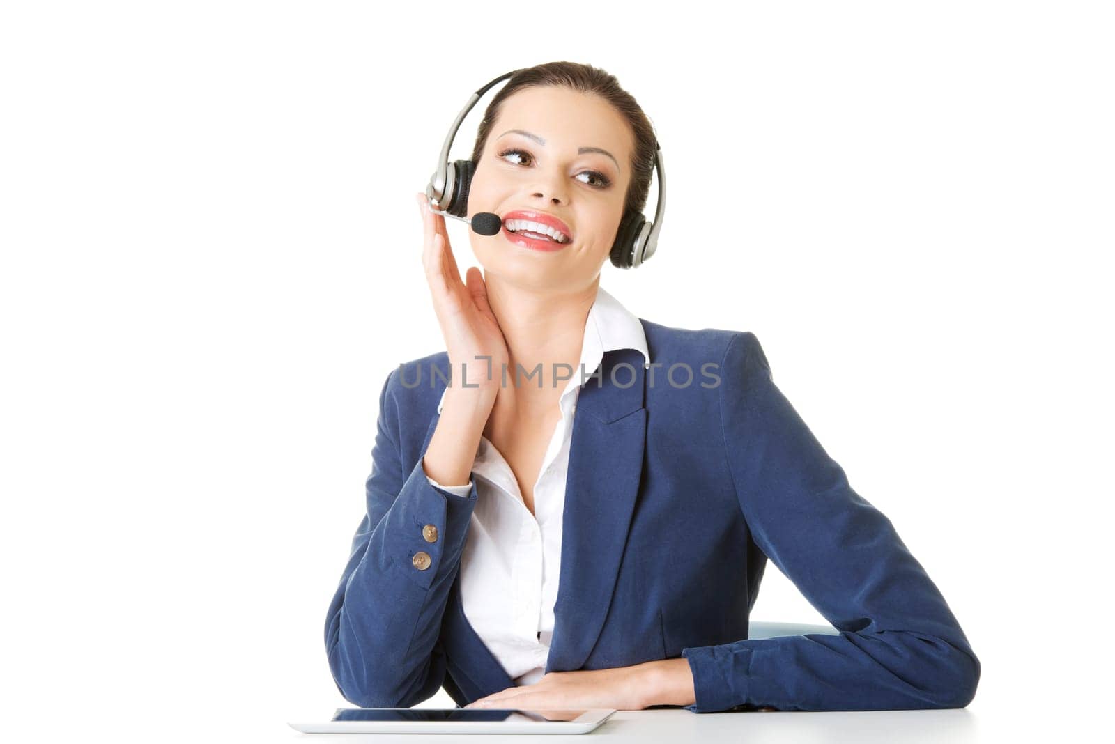 Beautiful young call-center assistant at the desk, isolated on white