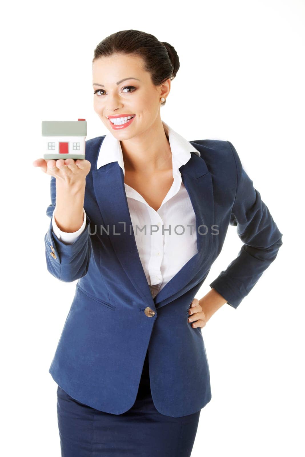Beautiful young businesswoman holding house model over white - real estate loan concept