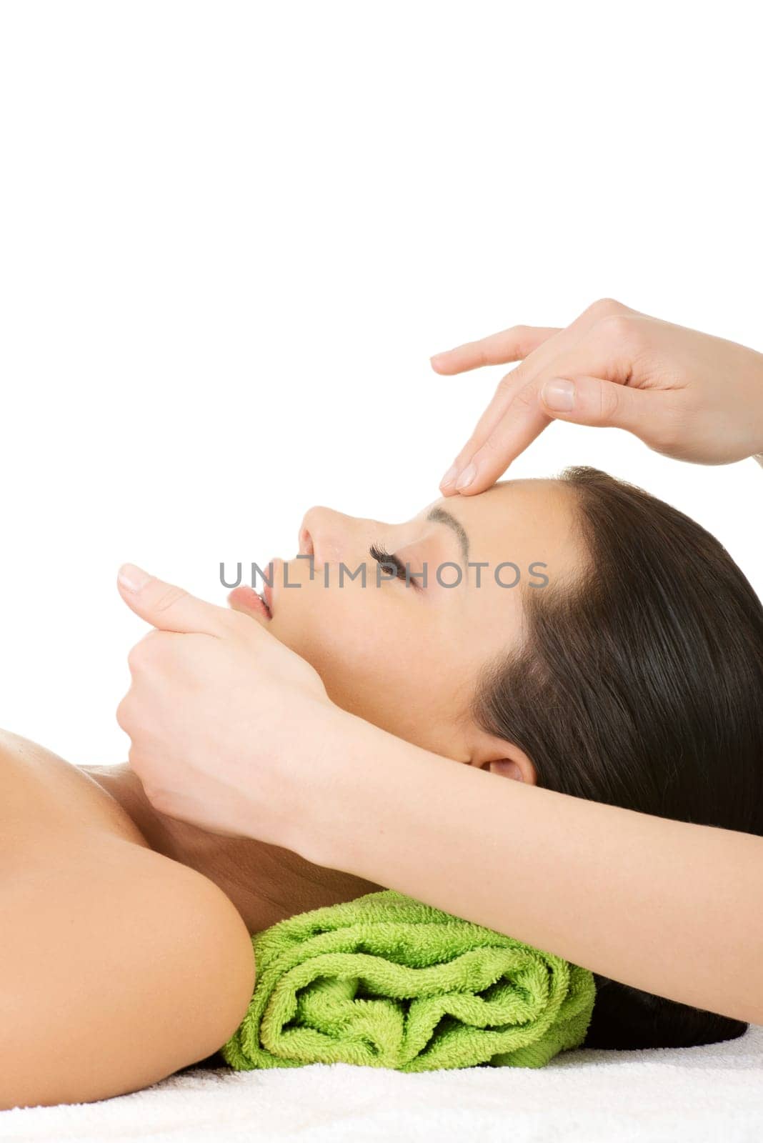 Beautiful young relaxed woman enjoy receiving face massage at spa saloon