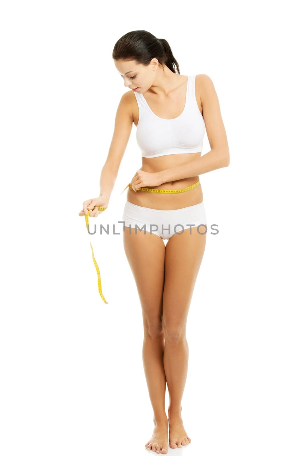 Happy young woman measuring her waist , isolated on white