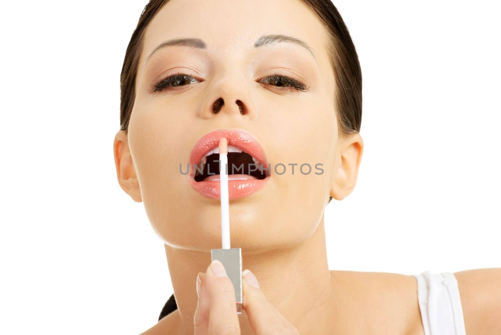 Beautiful young woman using Gloss, isolated on white