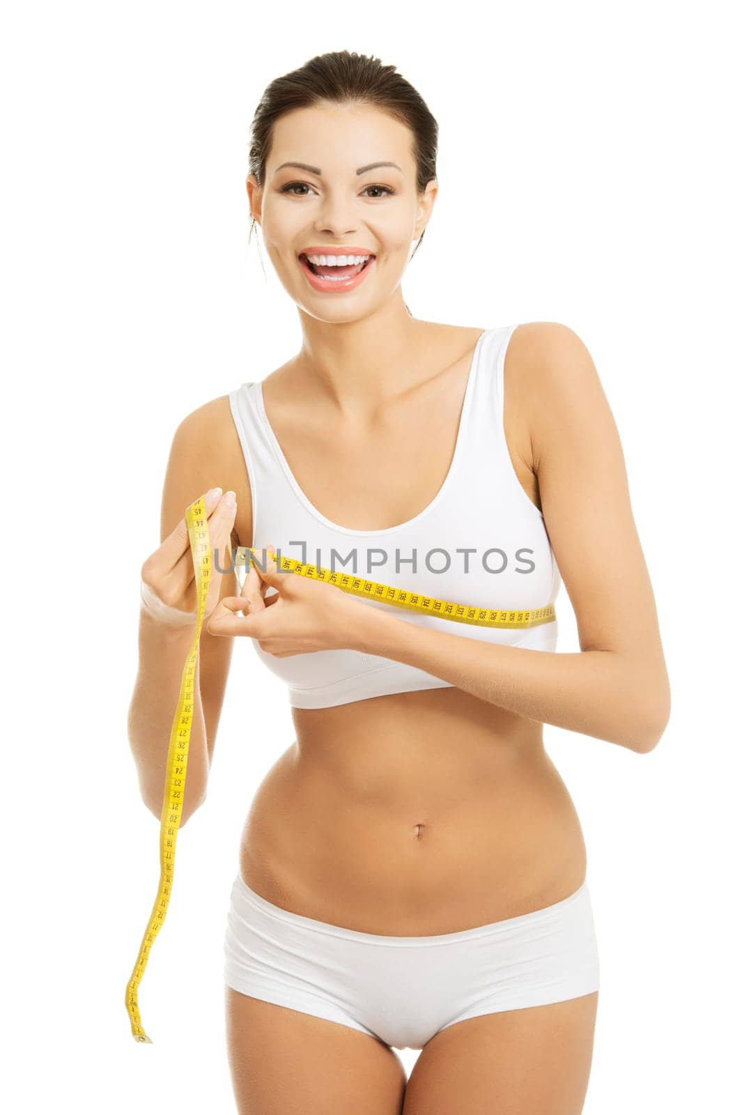Pretty smiling woman measuring breast with measurement type - isolated on white