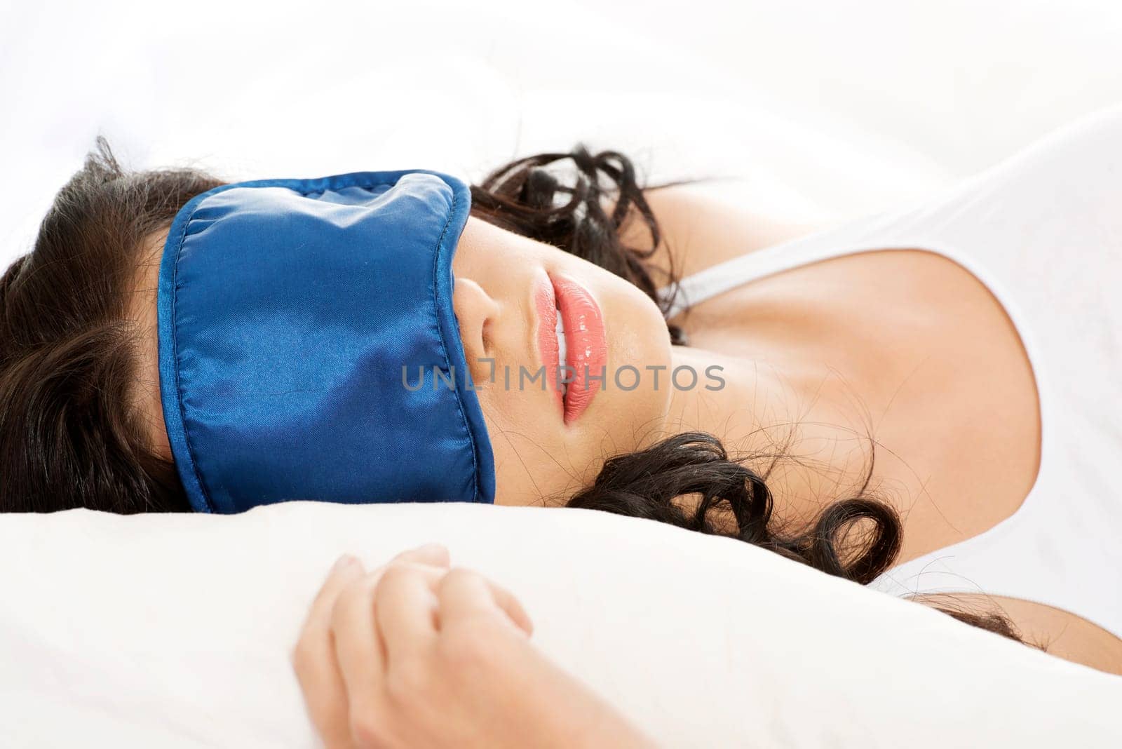 Beautiful happy young woman resting in bed