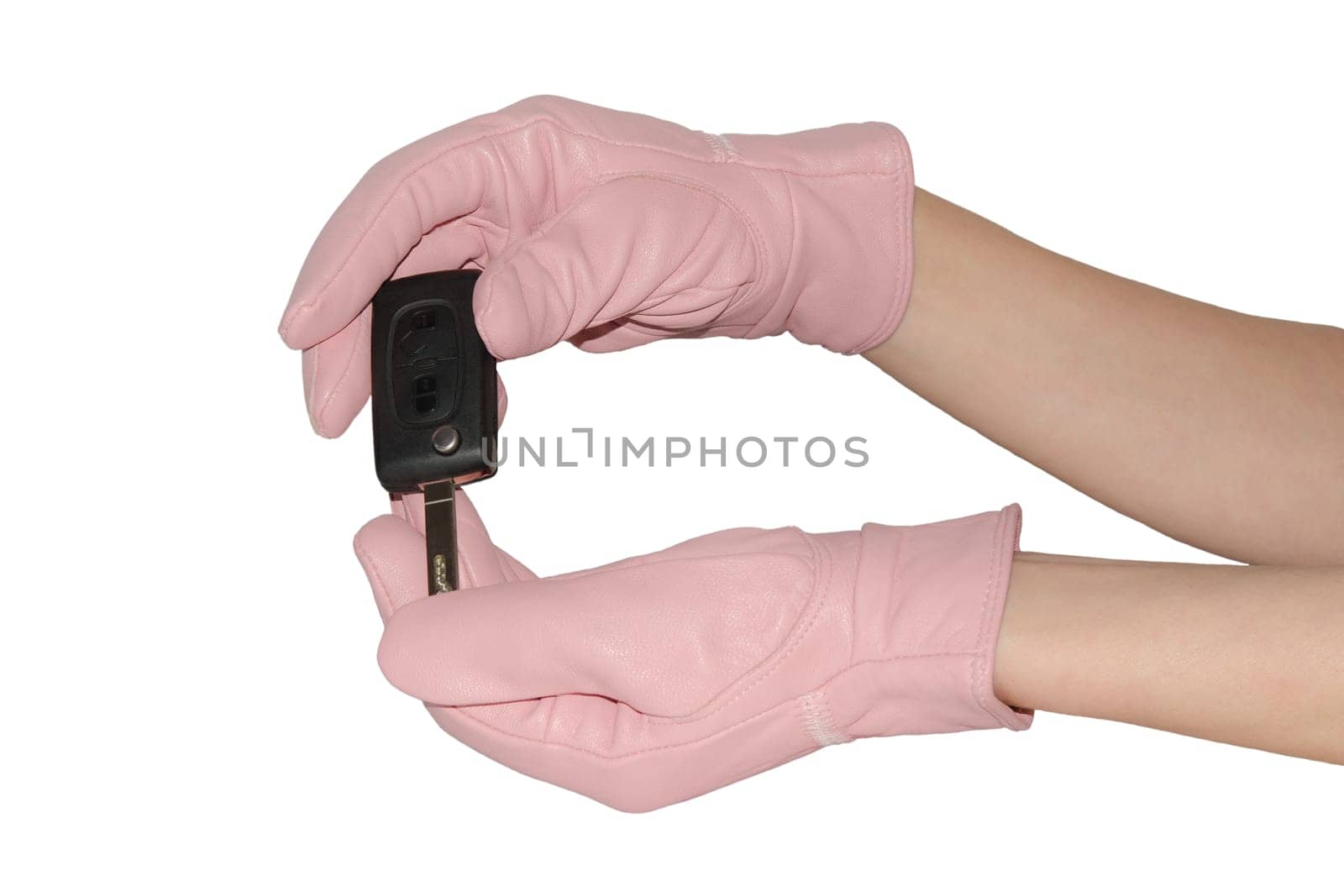 Graceful female hands in elegant pink gloves holding key from new car