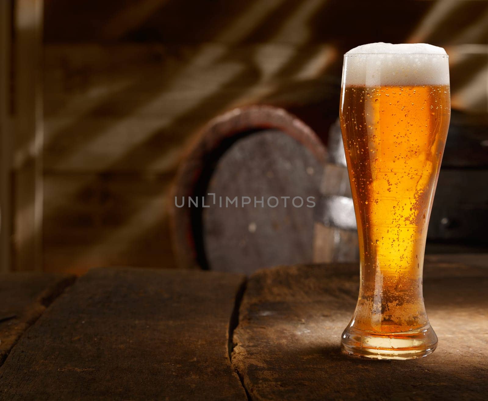 Closeup of a glass of fresh foamy beer on a table in a vintage beer cellar