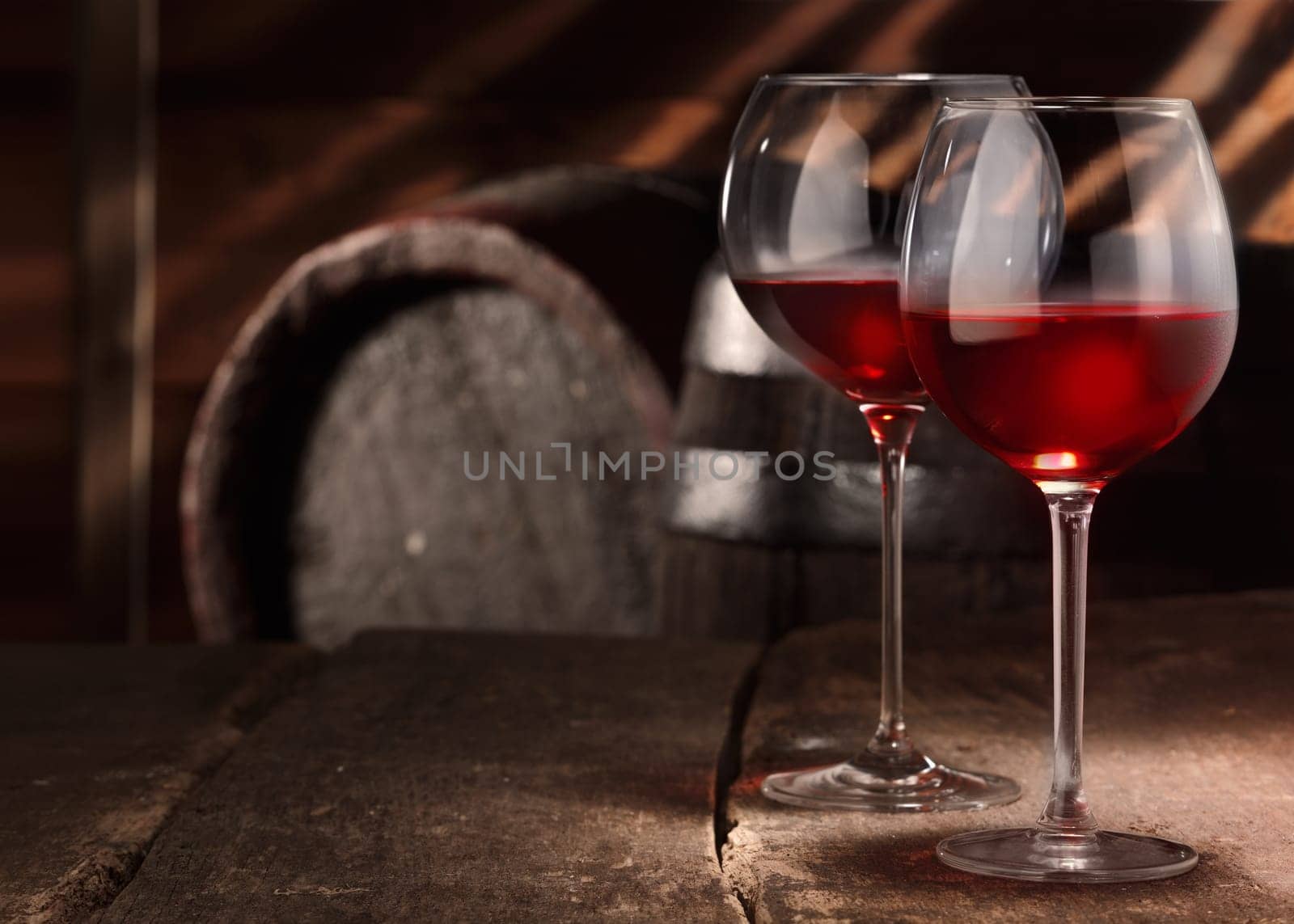 Two glasses of red wine on a table in a vintage beer cellar