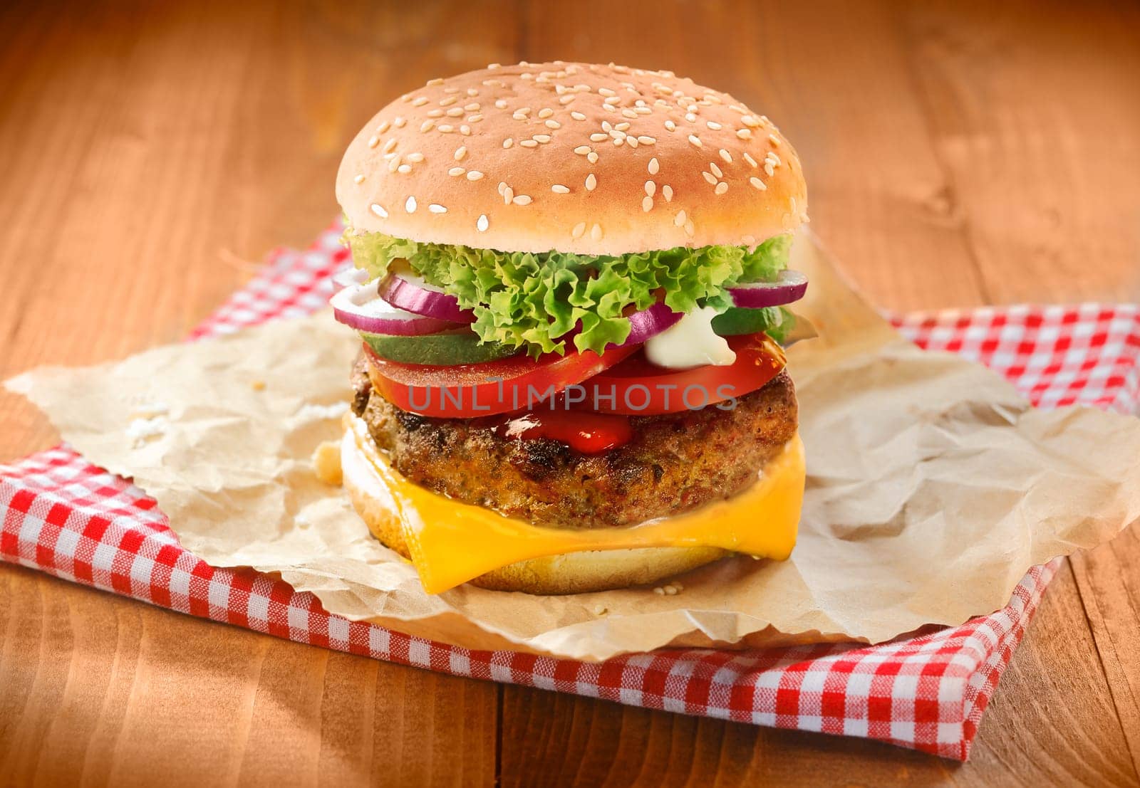 Hamburgers and french fries with sesame bun on brown paper and napkin