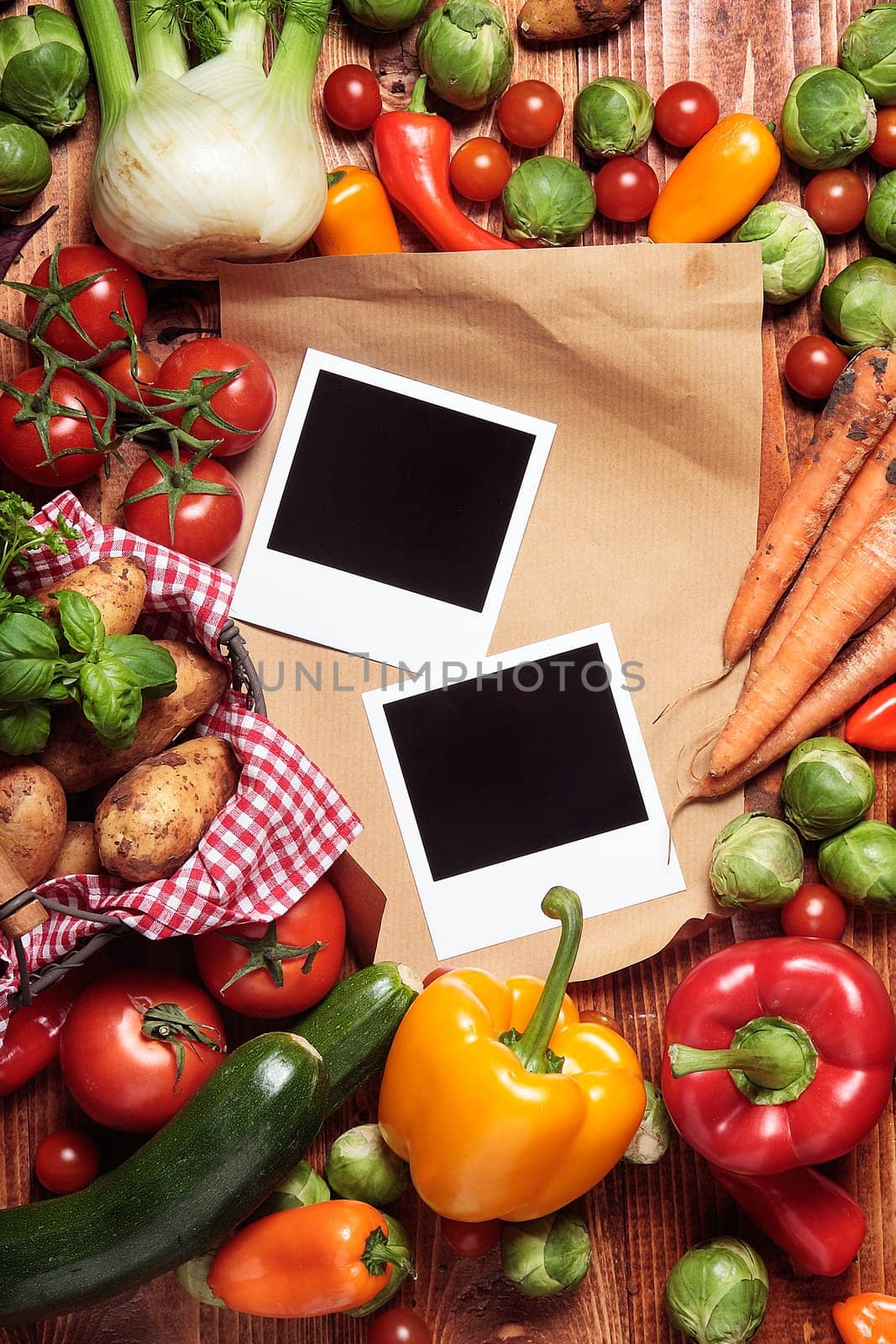 Garden fresh vegetables and blank brown paper and blank polaroid pictures