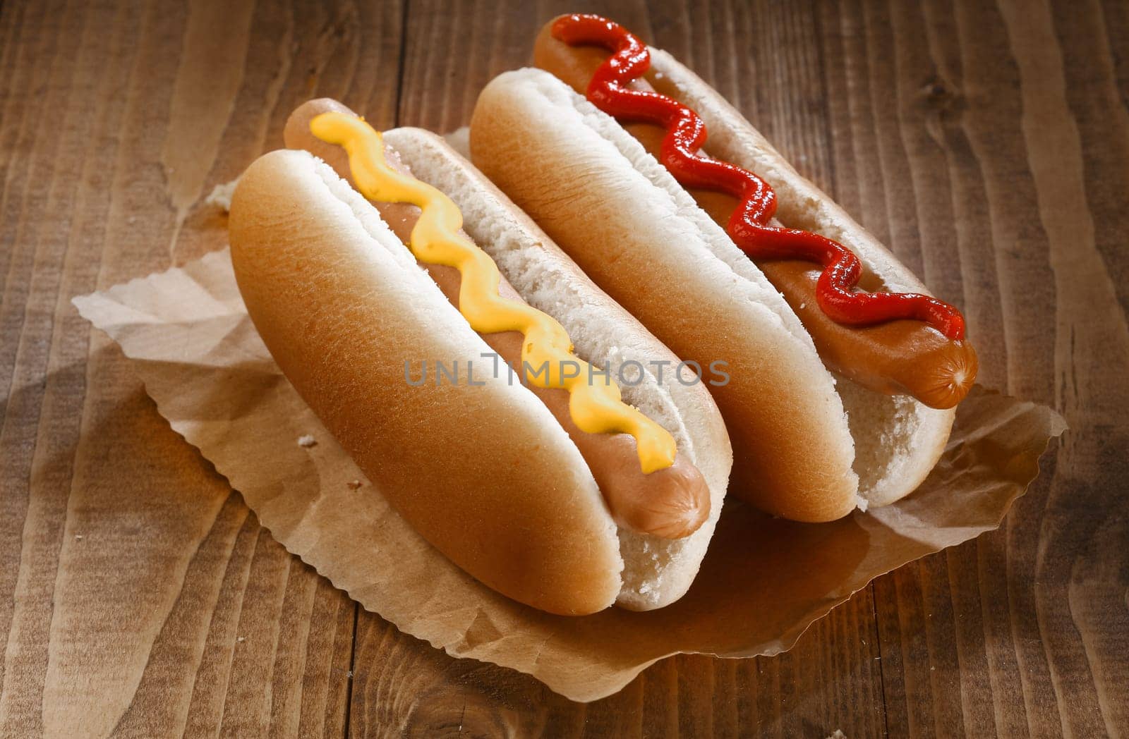 Two appetizing hotdogs with mustard and ketchup, close up